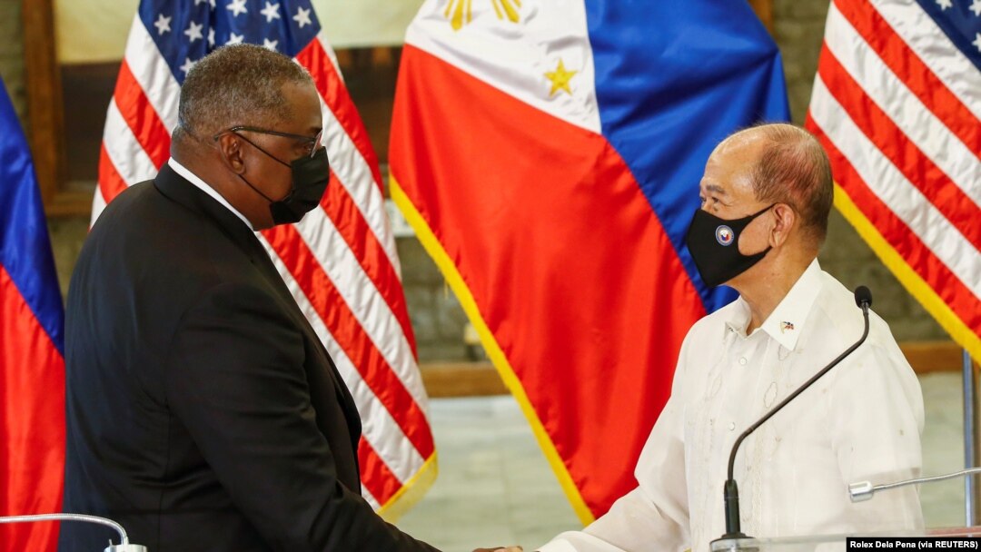 Menteri Pertahanan Amerika Serikat Lloyd Austin (kiri) dan Menteri Pertahanan Filipina Delfin Lorenzana (kanan) berjabat tangan setelah pertemuan bilateral di kamp militer Camp Aguinaldo di Quezon City, Metro Manila, Filipina, 30 Juli 2021. (Foto: Rolex D