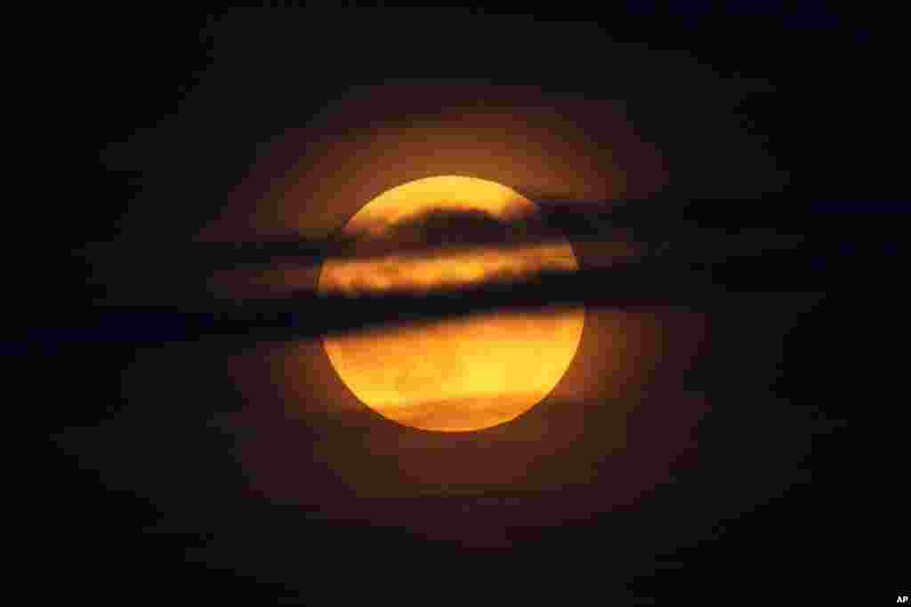 La luna se eleva entre las nubes sobre el océano Atlántico frente a la costa de Camden, Maine, el 17 de septiembre de 2024.