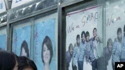 Women look at the poster of the concert of the Japanese Pop group SMAP, in Shanghai. Anti-Japanese protests have already flared in numerous locations around China, and the dispute has spilled into cultural ties, 23 Sep 2010