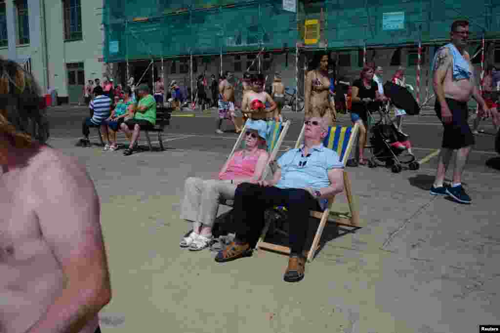 A couple sunbathe near Bournemouth beach in Bournemouth, southern England.