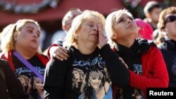 Fanáticos que no poderon ingresar al funeral observan la ceremonia a través de pantallas gigantes.
