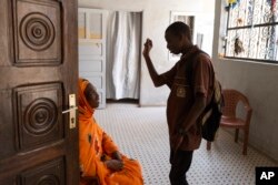 FILE—Mouhamed Sall communicates by sign with his mother Khadiatou Koundio as he arrives home from school in Pikine, Senegal, March 18, 2024.