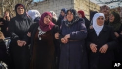 Relatives and neighbors mourn during the funeral procession for Syrian security force members killed in clashes with loyalists of ousted President Bashar Assad in coastal Syria, in the village of Al-Janoudiya, March 8, 2025.