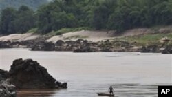 A fisherman works near the site of the proposed Xayaburi Dam in Paksey, northern Laos, file photo. 