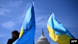 Sejumlah aktivis melambaikan bendera-bendera Ukraina di luar gedung Capitol, di Washington, AS, 23 April 2024. (Foto: Mandel Ngan/ AFP)