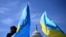 Sejumlah aktivis melambaikan bendera-bendera Ukraina di luar gedung Capitol, di Washington, AS, 23 April 2024. (Foto: Mandel Ngan/ AFP)
