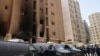نیروهای پلیس کویت بیرون ساختمانی که آتش‌سوزی در آن رخ داده است.