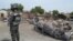 FILE - A Nigerian policeman stands guard by burned out cars and houses, following an attack by suspected Islamic extremists in Kawuri, Maiduguri, Nigeria.
