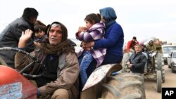 This photo released on March 7, 2018 by the Syrian official news agency SANA, shows Kurds fleeing from their villages where Turkish forces and Syrian rebels battle against Kurdish fighters, in Afrin, northern Syria. 