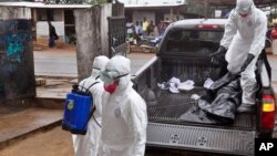 卫生人员在利比里亚把似乎死于埃博拉者的尸体抬上卡车