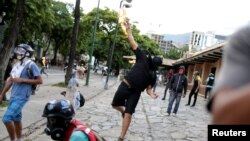 26일 베네수엘라 수도 카라카스에서 니콜라스 마두로 대통령의 개헌의회 구성 시도에 항의하는 시위대가 화염병을 던지고 있다.