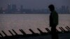 A visitor walks along on a beach equipped with anti-landing barricades, with the Chinese city of Xiamen seen in the background, in the Taiwan-controlled Kinmen islands, in Kinmen on May 17, 2024.