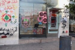 While banks opened this week, financial institutions in Beirut’s popular protesting areas remained closed, covered with graffiti expressing anger at political and financial officials, Nov. 21, 2019. (Heather Murdock/VOA)