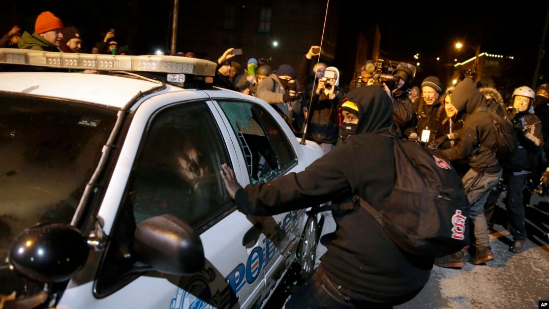 Demonstran merusak mobil polisi dekat Balai Kota Ferguson di Missouri (25/11). (AP/David Goldman)