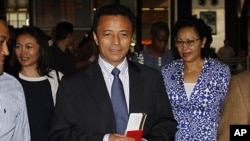 Former Madagascar leader Marc Ravalomanana and his wife Lalao (R) hold plane tickets after checking in at the O.R Tambo airport in Johannesburg, January 21, 2012.
