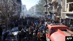 Syrians gather at the site of a car bomb explosion in al-Zahra neighborhood in Homs, Dec. 12, 2015. Fifteen civilians were killed and dozens more wounded when the car bomb struck the central Syrian city of Homs, the provincial governor told. 