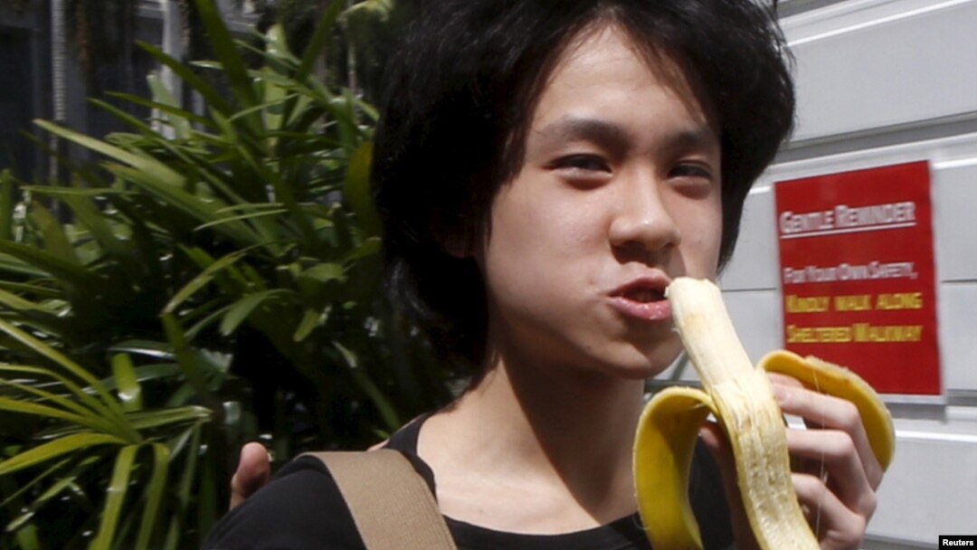Amos Yee makan pisang saat tiba di pengadilan Singapura untuk konferensi pra-peradilan (17/4). (Reuters/Edgar Su)