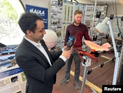 Dr. Mostafa Hassanalian, a mechanical engineering professor and Ph.D student, Brenden Herkenhoff, analyse a heat map on a taxidermy bird drone at New Mexico Institute of Mining and Technology in Socorro, New Mexico, U.S. on March 22, 2023. (REUTERS/Liliana Salgado)