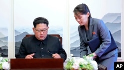 지난해 4월 파주 판문점 평화의 집에서 열린 남북정상회담 직전, 김정은 북한 국무위원장이 방명록 작성하려고 하자 김여정 당 중앙위원회 제1부부장(오른쪽)이 보조를 하고 있다. 