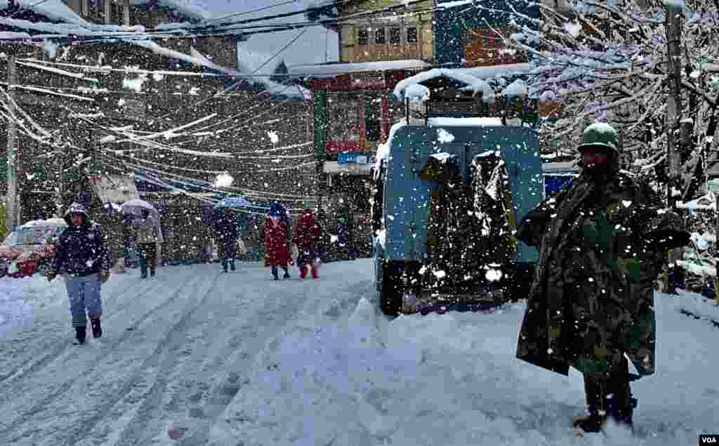 سرینگر میں شدید برفباری میں سیاحوں کے تحفظ کے لیے سیکیورٹی اہلکار بھی سڑک پر موجود ہے۔