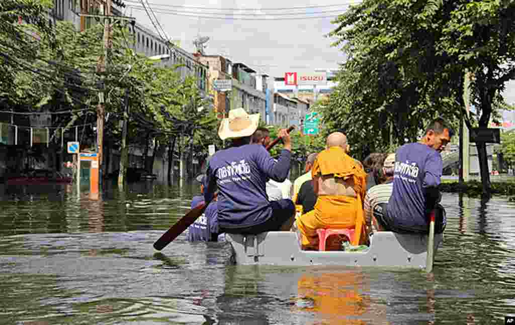 海军小舟载着一名僧人和其他居民驶过街区