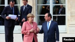 Kanselir Jerman Angela Merkel berbicara dengan Presiden Perancis Francois Hollande di Paris di sela KTT Balkan 4 Juli 2016 lalu (foto: dok).