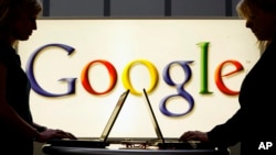 FILE - Exhibitors work on laptop computers in front of a sign of the Google logo at the industrial fair Hannover Messe, Germany, Apr. 17, 2007. Google lost its final legal challenge against a EU for giving its own shopping recommendations an illegal advantage in search results. 