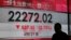 A man walks past a display of the Hang Seng Index at a bank in Hong Kong, Nov. 9, 2016.