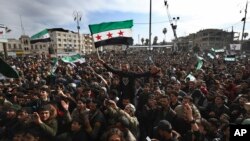 FILE - Thousands of anti-Syrian government protesters shout slogans and wave revolutionary flags to mark 10 years since the start of a popular uprising against President Bashar Assad's rule, March 15, 2021.