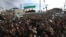 FILE - Thousands of anti-Syrian government protesters shout slogans and wave revolutionary flags to mark 10 years since the start of a popular uprising against President Bashar Assad's rule, March 15, 2021.