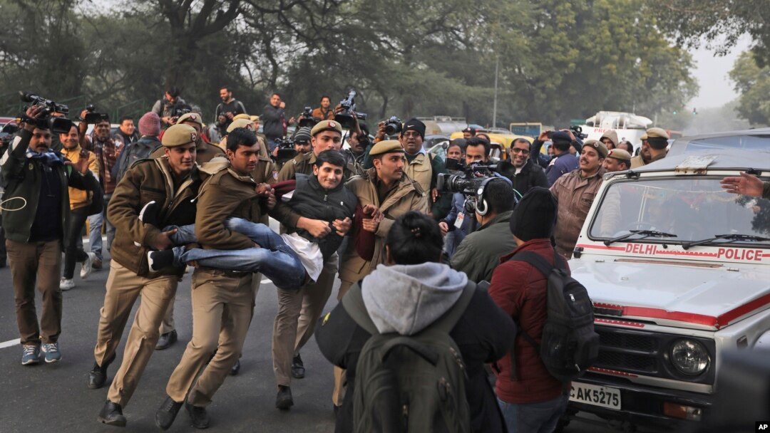 Seorang demonstran ditahan oleh seorang polisi di luar Uttar Pradesh Bhawan saat berlangsungnya aksi protes terhadap UU kewarganegaraan baru dan kekerasan oleh polisi di negara bagian itu, di New Delhi, India, 27 Desember 2019.
