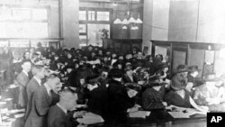 Americans fill out forms at an Internal Revenue Service office in 1920, seven years after the personal income tax was introduced.