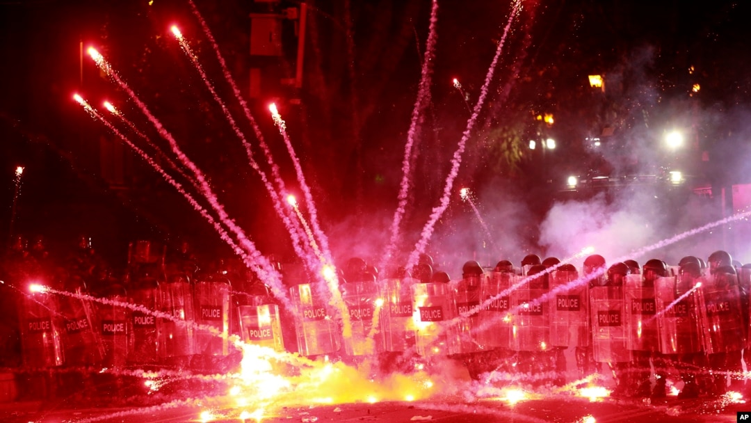 Demonstrators use firecrackers against police during a rally against the government's decision to suspend negotiations on joining the European Union for four years, outside the parliament building in Tbilisi, Georgia, Dec. 1, 2024. 