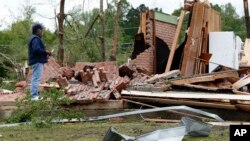 A friend of the owner reviews the remains of a storm damaged house in Morton, Miss., April 19, 2019, following a possible tornado touchdown Thursday afternoon.