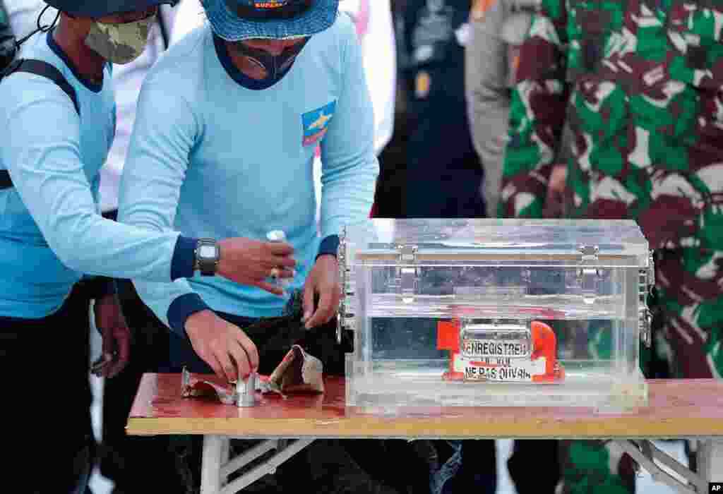 Indonesian Navy personnel handle a box containing the flight data recorder recovered from the crash site of the Sriwijaya Air flight SJ-182 in the Java Sea at Tanjung Priok Port.