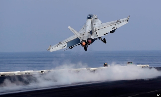 Sebuah jet tempur Angkatan Laut A.S. lepas landas dari dek A.S. Kapal induk Dwight D. Eisenhower. (Foto: AP)