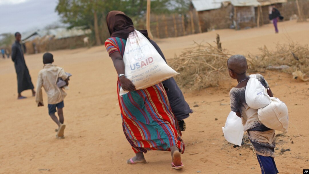 A newly-arrived Somali family carry their supply of aid outside Dadaab, Eastern Kenya, 100 kms (60 miles) from the Somali border, Aug. 5, 2011