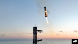 This image provided by SpaceX shows SpaceX's mega rocket booster returning to the launch pad to be captured during a test flight Sunday, Oct. 13, 2024, in Boca Chica, Texas. (SpaceX via AP)