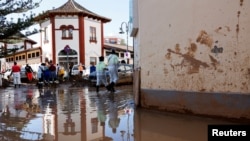 Volunteers clean up around a marketplace affected by flooding in Catarroja, Valencia, Spain, Nov. 11, 2024.