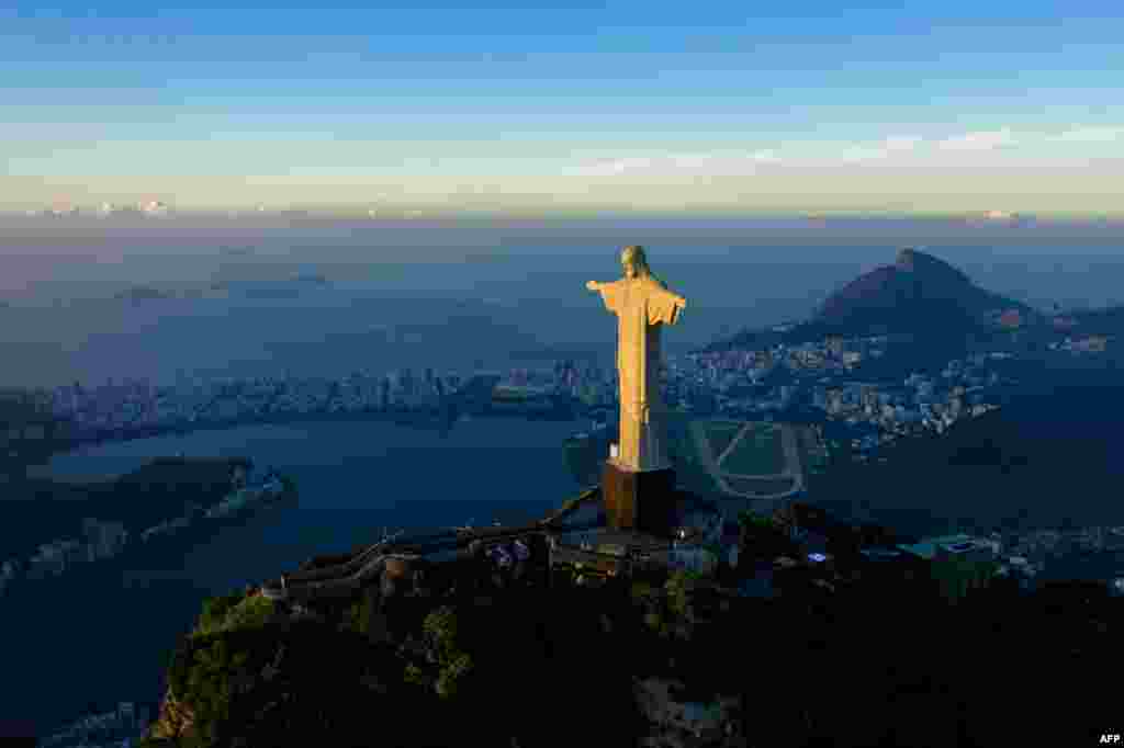 올해 10월 건립 90주년을 앞두고 있는 브라질 리우데자네이루의 &#39;구원의 그리스도상&#39;이 일출 햇살을 받아 빛나고 있다.