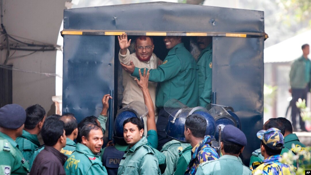 A.T.M. Azharul Islam, asisten sekretaris jenderal partai Jamaat-e-Islami, melambaikan tangannya memasuki mobil polisi setelah mengikuti sidang pengadilan yang menjatuhkan vonis hukuman mati untuknya di Dhaka, Bangladesh, 30/12/2014.
