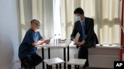 Wu Huan (kiri) dan Wang Jingyu duduk bersama di sebuah tempat yang aman di Ukraina, Rabu, 30 Juni 2021. (AP Photo)