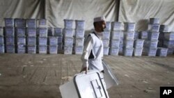 An Afghan election worker carries ballot boxes at the warehouse of Afghanistan's Independent Election Commission in Kabul, Afghanistan, a few days after parliamentary elections on September 18, 2010.