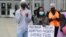 A protester holds a sign with the names of people who have died while in police custody or during police actions, or who were victims of alleged racially motivated killings, June 5, 2020, in Tacoma, Wash.