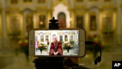 An Orthodox Church priest speaks to believers during a live broadcast in an empty church in Moscow, Russia, April 19, 2020. 