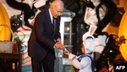 President Joe Biden hands out treats to children during a Halloween celebration at the White House in Washington, Oct. 30, 2024. 