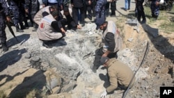 Hamas security services personnel inspect the site of a Tuesday explosion that occurred as the convoy of Palestinian Prime Minister Rami Hamdallah entered Gaza through the Erez crossing with Israel, on the main road in Beit Hanoun, Gaza Strip, March 13, 2018. 