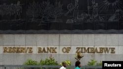FILE - People walk past the Reserve Bank of Zimbabwe building in Harare, Zimbabwe, Feb. 25, 2019. 