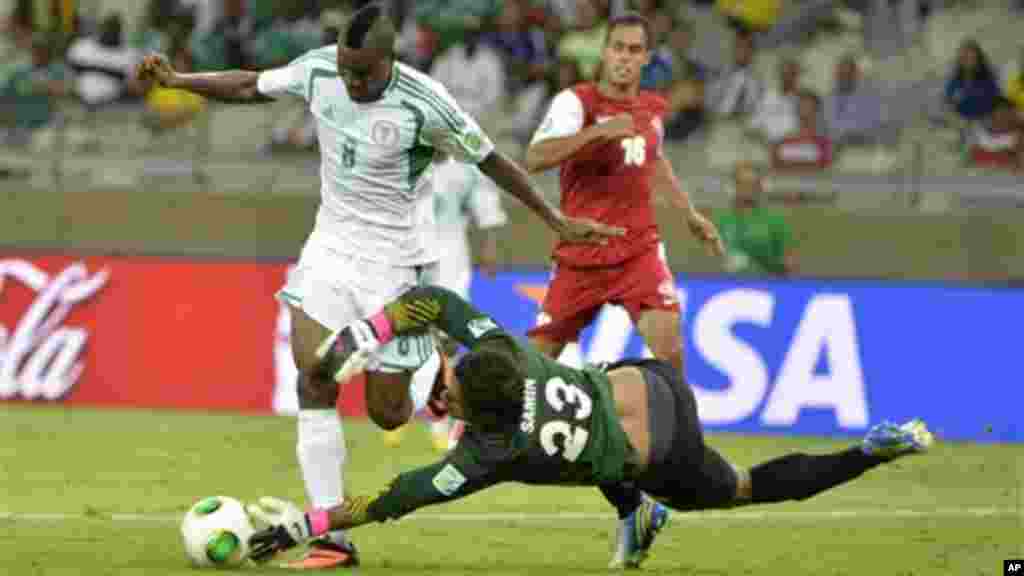 Nigeria's Brown Ideye is stopped by Tahiti goalkeeper Xavier Samin, right, during the Confederations Cup match between Tahiti and Nigeria.