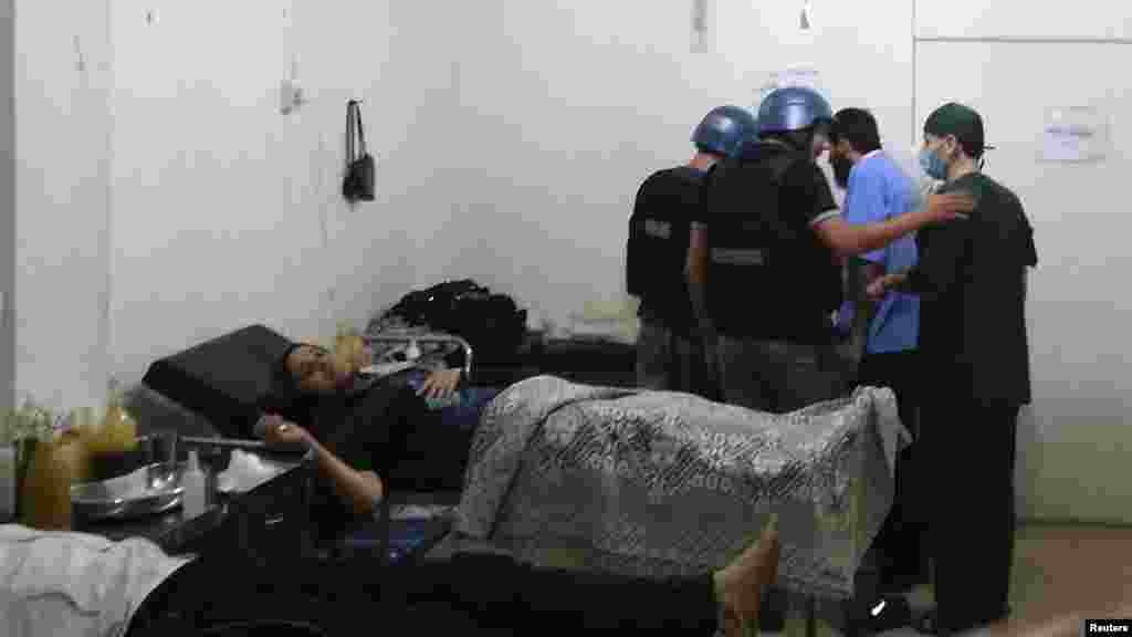 U.N. chemical weapons experts visit a hospital where wounded people affected by a suspected gas attack are being treated, in a southwestern Damascus suburb, August 26, 2013. 